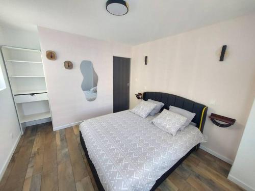 une chambre avec un lit avec des draps blancs et des oreillers dans l'établissement El bahia 2 , appartement centre-ville, à Boulogne-sur-Mer