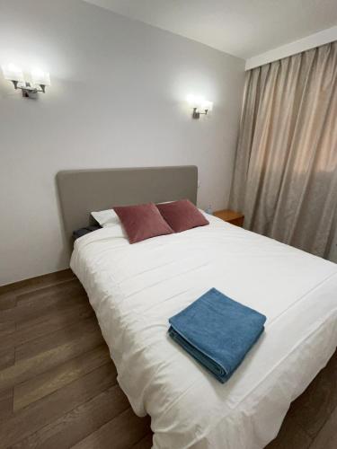 - un grand lit blanc avec une serviette bleue dans l'établissement Paris chambre luxe -opéra 15mins-chambre avec salle de bain commune, à Paris