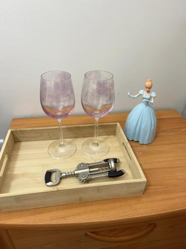 - un plateau en bois avec deux verres à vin et une poupée dans l'établissement Paris chambre luxe -opéra 15mins-chambre avec salle de bain commune, à Paris