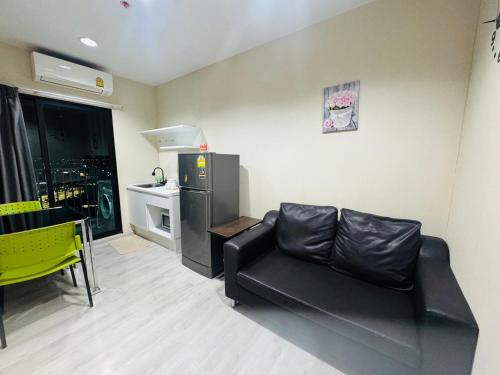 a living room with a black couch and a refrigerator at 1 Bedroom Next to IKEA,Central Westgate46 in Ban Bang Krabu