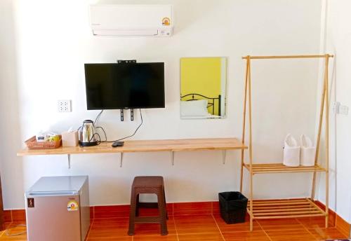 a room with a desk with a tv and a stool at บ้านชมดาวรีสอร์ทบึงโขงหลง in Ban Don Klang