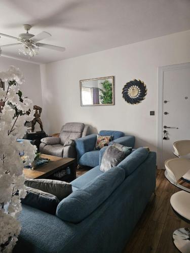 a living room with two blue couches and a table at De Pearl Nest Home Tatu City- Nairobi in Tatu City