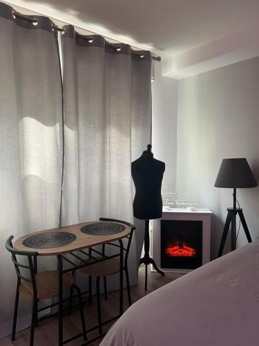 une chambre avec un lit, une table et une cheminée dans l'établissement LE CARRÉ STRASBOURGEOIS - LOGEMENT ENTIER AU CENTRE DU NEUDORF f1, à Strasbourg