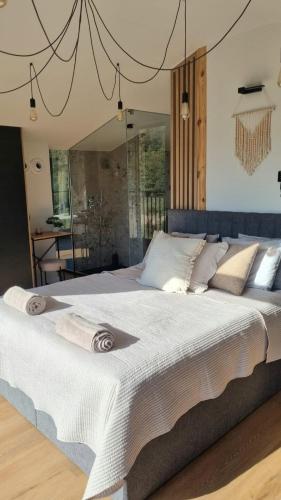 a large bed with white sheets and pillows at Ostoja Liskówka in Potrzanowo