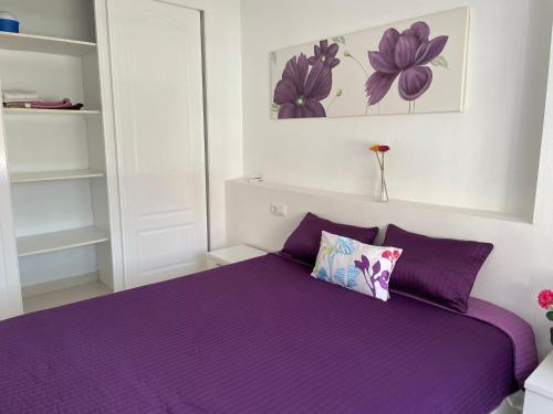 a bedroom with a purple bed with purple pillows at Lovely 2 bedroom apartment on El Divino, Los Alcazares in Los Alcázares