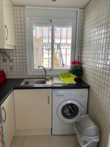 a kitchen with a washing machine and a sink at Lovely 2 bedroom apartment on El Divino, Los Alcazares in Los Alcázares