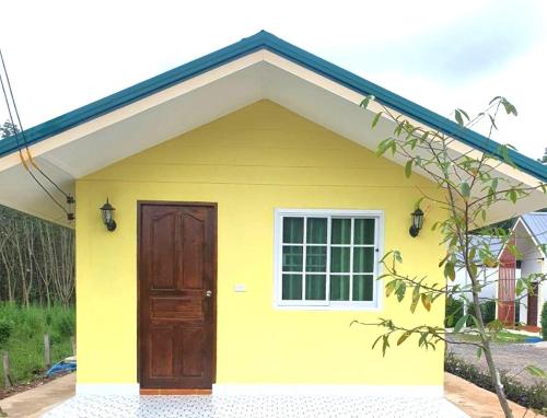 a yellow house with a door and a window at บ้านชมดาวรีสอร์ทบึงโขงหลง in Ban Don Klang