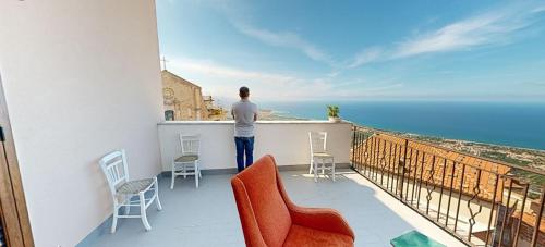 a man standing on a balcony looking out at the ocean at Bed & Breakfast StudioArcodia- in San Marco dʼAlunzio