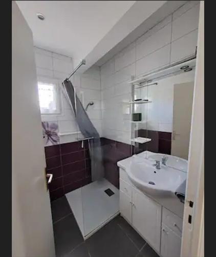 une salle de bain blanche avec un lavabo et un miroir dans l'établissement Maison de vacances à 500m de la mer, à Santec