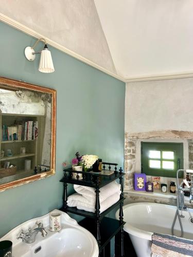 une salle de bain avec une baignoire, un lavabo et un miroir dans l'établissement Cottage normand - charme et authenticité, à Omonville-la-Rogue