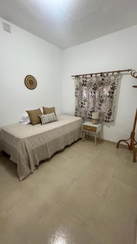 Un dormitorio blanco con una cama y una mesa. en Casa Anita, en Fuengirola