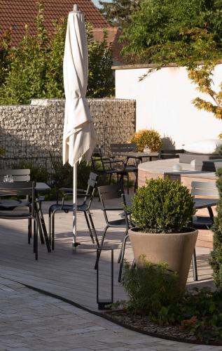 an umbrella sitting on a patio with tables and chairs at Hôtel de France in Montmarault
