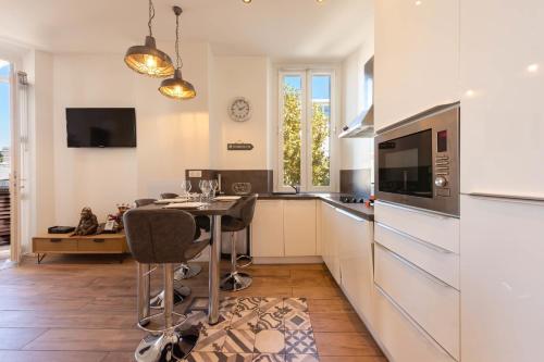 une cuisine avec une table avec des chaises et un micro-ondes dans l'établissement Downtown Cannes walk to Beaches and Croisette, à Cannes