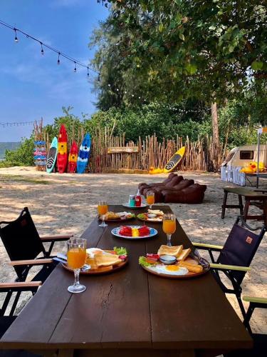 a wooden picnic table with food and drinks on it at Long Beach Club Krabi in Ao Nang Beach