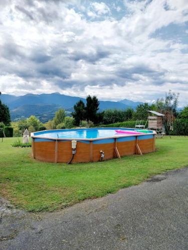 une grande piscine au milieu d'un champ dans l'établissement Gîte ETH ARREYEN avec piscine privée et magnifique vue sur Pyrénées, à Tilhouse