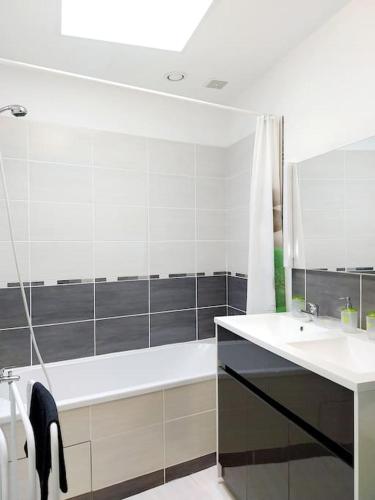 une salle de bain blanche avec une baignoire et un lavabo dans l'établissement Gîte ETH ARREYEN avec piscine privée et magnifique vue sur Pyrénées, à Tilhouse