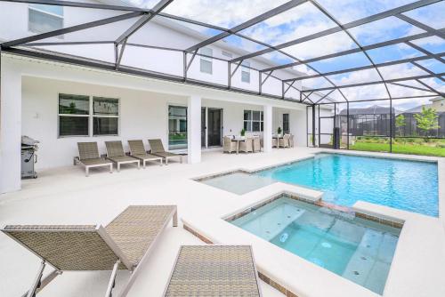 a swimming pool with a glass roof on a patio at Upstay - Magic Mansion w Pool-Spa-Cinema-Games in Kissimmee