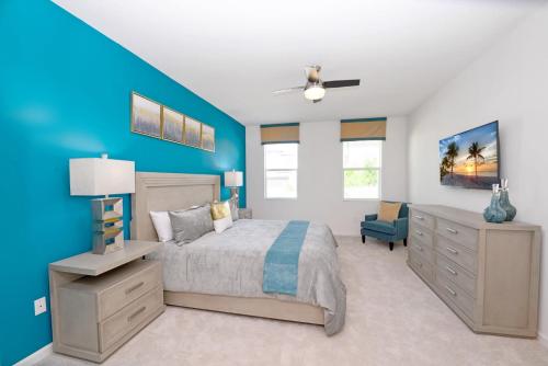 a bedroom with a bed and a blue wall at Upstay - Magic Mansion w Pool-Spa-Cinema-Games in Kissimmee