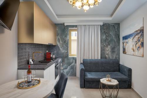 a kitchen and living room with a table and a couch at Royal Gold City Suites by Omilos Hotels in Heraklio Town