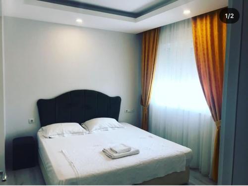 a bedroom with a large bed with a window at akdenız suıtes in Altınkum