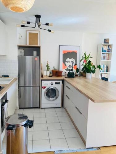 une cuisine avec un réfrigérateur et une machine à laver dans l'établissement Bel appartement à Pantin avec balcon, à Pantin