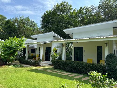 a white house with a lawn in front of it at Hanoii House in Ko Mak