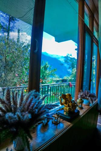 a window with potted plants on a window sill at The Manu Emerald # farmHouse # top selling cottage in manali # peaceful heritage cozy stay # lawn with bonfire # most awarded in Manāli