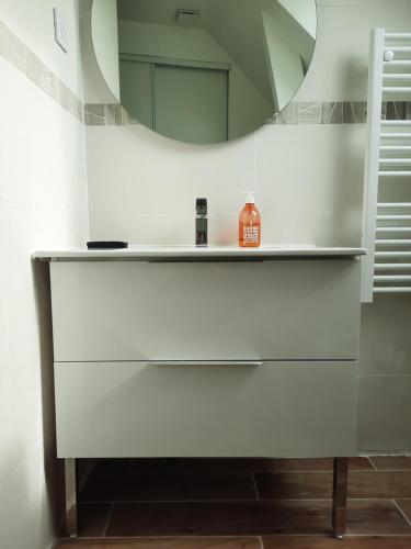 a bathroom with a white dresser with a mirror at Duplex avec vue sur mer-La Rose des Vents in Saint-Côme-de-Fresné