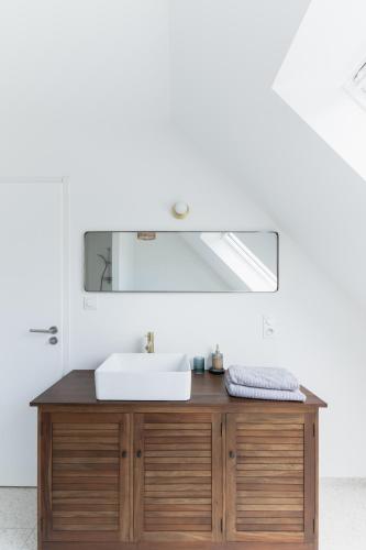 une salle de bain avec un lavabo et un miroir dans l'établissement Jolie Maison avec piscine intérieure à 5 minutes des plages, à Landunvez