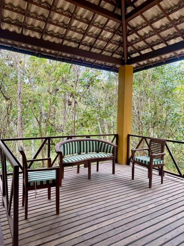 two benches on a deck with trees in the background at Sitio Ingá in Guaramiranga