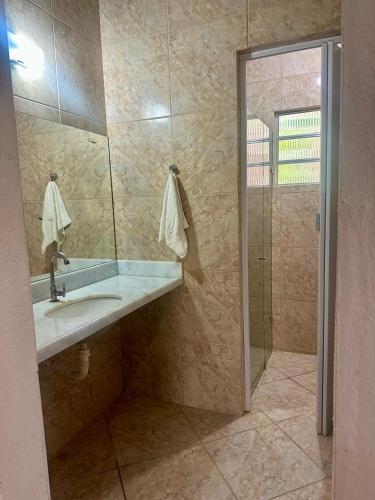 a bathroom with a sink and a shower with a mirror at Sitio Ingá in Guaramiranga
