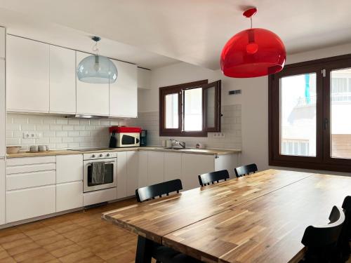 a large kitchen with a wooden table and chairs at Espectacular Sunny House in the beach in Cunit
