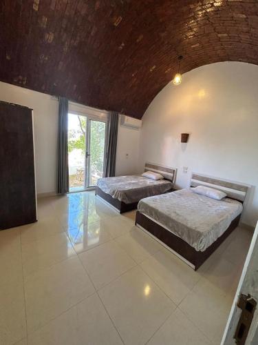 a bedroom with two beds and a large window at The House Of Love in Luxor