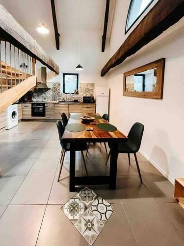 une salle à manger avec une table et des chaises en bois dans l'établissement La Bigourdane - Maison entre Tarbes & Lourdes, à Louey