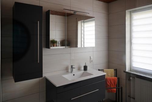 a bathroom with a sink and a mirror at Ferienwohnung Saarblick Besseringen in Mettlach