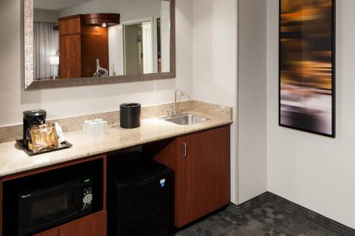 a kitchen with a sink and a mirror at Courtyard by Marriott Miami at Dolphin Mall in Miami