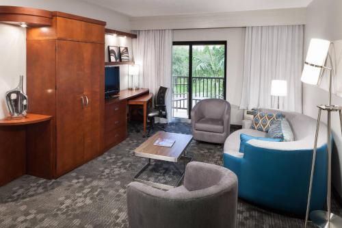a living room with a couch and a desk at Courtyard by Marriott Miami at Dolphin Mall in Miami