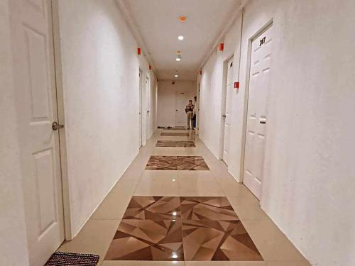 a corridor of a hallway with tile floors and white walls at Greenwood Residences in Bacolod