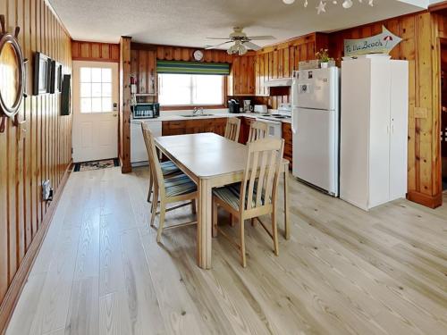 a kitchen with a table and a white refrigerator at Four By The Shore in Surf City
