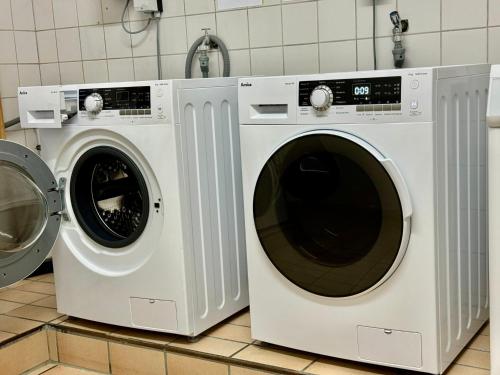 two washing machines sitting next to each other in a kitchen at JJ Living - Alpenblick 073 in Scheidegg