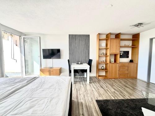 a bedroom with a bed and a desk and a table at JJ Living - Alpenblick 073 in Scheidegg