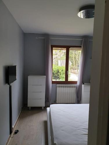 une chambre avec un lit blanc et une fenêtre dans l'établissement Appartement dans campagne aixoise, à Ventabren