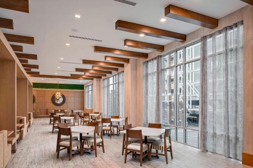 a dining room with tables and chairs and large windows at Residence Inn by Marriott Greenville Downtown in Greenville