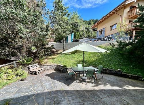 a patio with a table and chairs and an umbrella at Peace & comfort - Great views and location in Villars-sur-Ollon