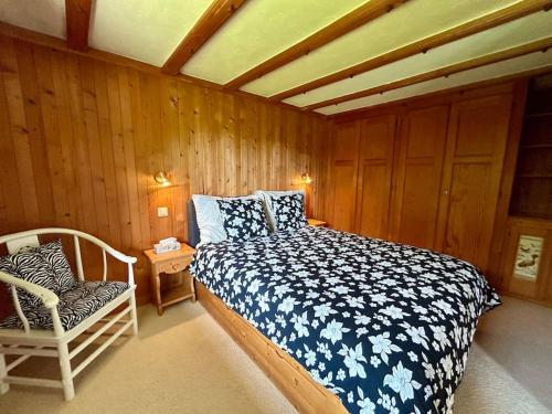 a bedroom with a bed and a chair in it at Peace & comfort - Great views and location in Villars-sur-Ollon