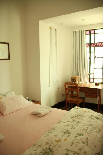 a bedroom with a bed and a desk and a table at La Casona in La Plata