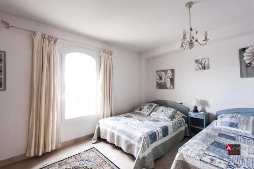 une chambre avec deux lits et une fenêtre dans l'établissement Marina Port du Roy, à Aigues-Mortes