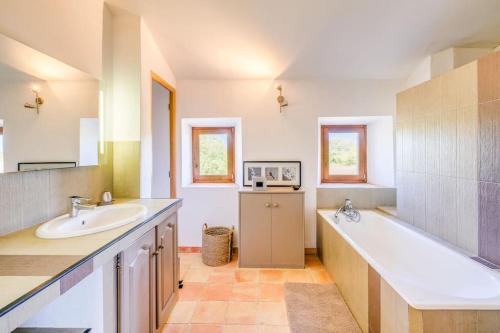 a bathroom with two sinks and a large tub at 4 stars farmhouse, heated pool, view, 15 people in Bonnieux