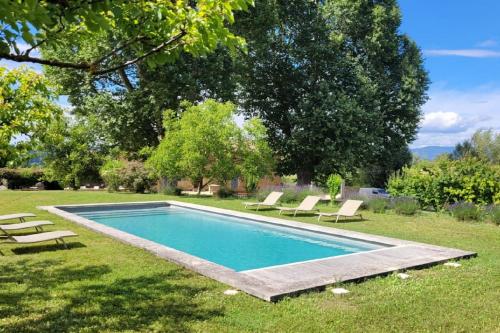 une piscine dans une cour avec des chaises longues dans l'établissement 4 stars farmhouse, heated pool, view, 15 people, à Bonnieux