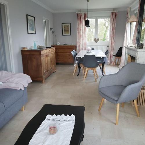 un salon avec un canapé, une table et des chaises dans l'établissement Maison 5 pièces en bord de mer et campagne, à Pordic